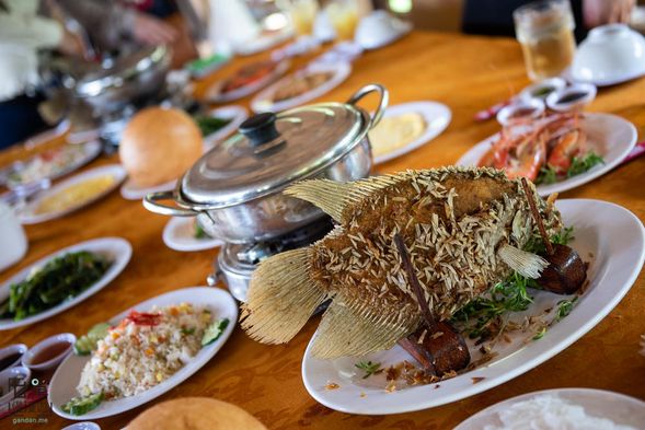 湄公河特產名菜油泡象魚風味餐:油炸酥脆的象耳魚,將魚肉與青菜一起用米紙皮包卷蘸上百搭魚露。