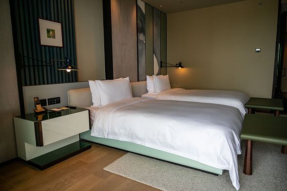 冰箱亦採隱藏式設計,要用的話再將拉門拉出即可,草綠色的櫃子還有放置咖啡及茶包,咖啡則為手沖咖啡。另外有台純白的藍芽立響可以隨時連線播發音樂,電視遙控和電話則有提供中文顯示,相當貼心。