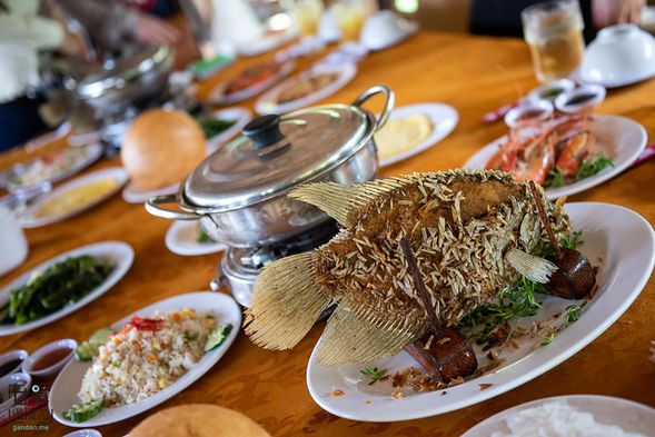 湄公河特產名菜油泡象魚風味餐:油炸酥脆的象耳魚,將魚肉與青菜一起用米紙皮包卷蘸上百搭鱼露。