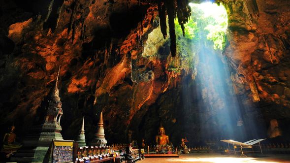 Khao Luang Cave is a famous limestone cave located in Phetchaburi Province near Hua Hin, Thailand. The cave houses several Buddha statues, the most famous of which is a reclining Buddha statue set up by King Rama V. The skylight in the cave lets in sunlight, illuminating the Buddha statues inside the cave, creating a mysterious and solemn atmosphere. Khao Luang Cave is a popular attraction for Buddhist believers and tourists, attracting people to come and worship and appreciate its natural beauty.