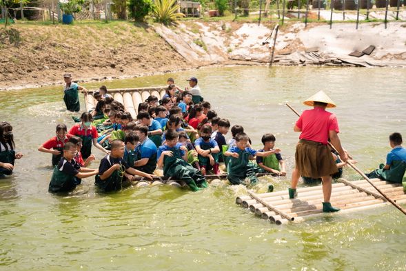 著青蛙裝坐膠筏下魚池圍網捕魚