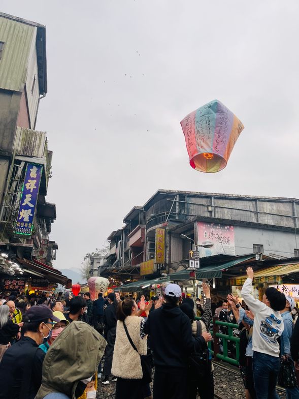 十分駅 (約50分~1時間)
「天燈上げ」で有名な十分。毎年旧正月になると、願い事を書いた天燈をいっせいに夜空に放ちます。その時期でなくてもいつでも体験できます!平渓線の両脇にはお店がずらっと立ち並んでおり、買い物も楽しめます。
天燈を上げるときに店員がお写真をお撮りします。