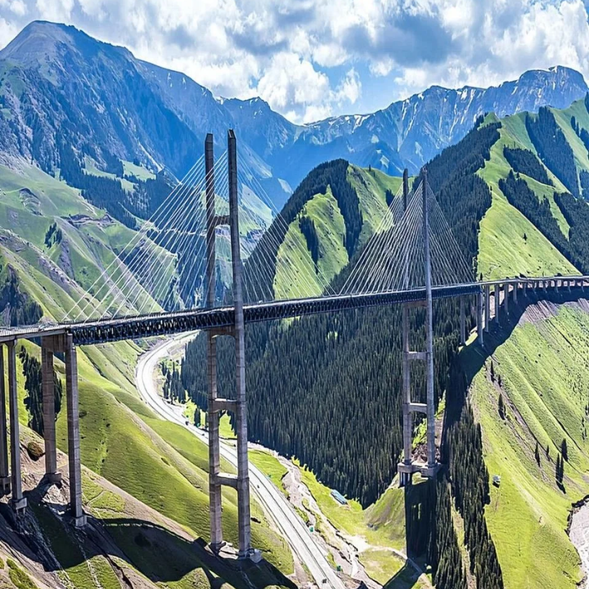 【果子溝大橋】是通往伊犁的標誌性建築之一,被譽為“中國最美高架橋”。大橋橫跨果子溝峽谷,整個橋身宛如一條巨龍騰空而起,氣勢恢宏。途經此地,您可以遠眺大橋與周邊的青山綠水相互映襯,如詩如畫的景色令人難忘。