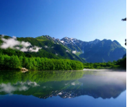 烧岳喷发堰塞形成的湖泊,湖面枯木与雪山倒影相映,晨雾弥漫的画面极具氛围感