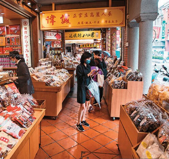 迪化街(ディーファージエ)老街
最初の訪問地は百年以上の歴史を誇る迪化街です。ここは台北で最も代表的な伝統的商店街で、赤レンガのアーケードやバロック様式の建物が並び、清代から日本統治時代にかけての繁栄を今に伝えています。乾物、漢方薬、茶葉、布店の香りが通りに漂い、新興のクリエイティブショップや手作りスイーツ店が老街に新たな活気を与えています。霞海城隍廟に足を運べば、地元の人々の信仰心や「月老」による恋愛成就の祈りも感じられます。