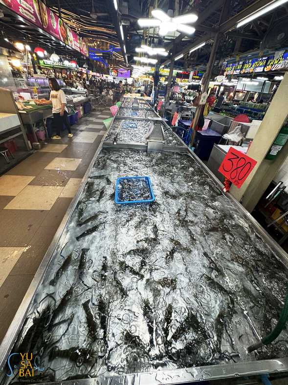 新鮮的巨型河蝦等著您—沉浸在吞武里市場著名海鮮攤位的熱鬧氛圍中