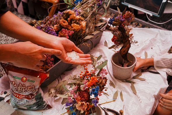 Once your flowers are arranged, you’ll add white sand to the base.