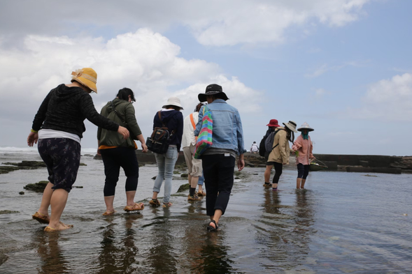Walking in the intertidal zone wearing straw sandals