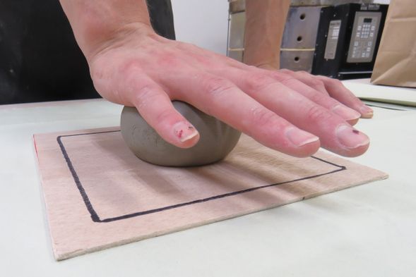 3伸ばす:板を敷いたらその上に粘土を置いて、手のひらを使って伸ばしていきます。