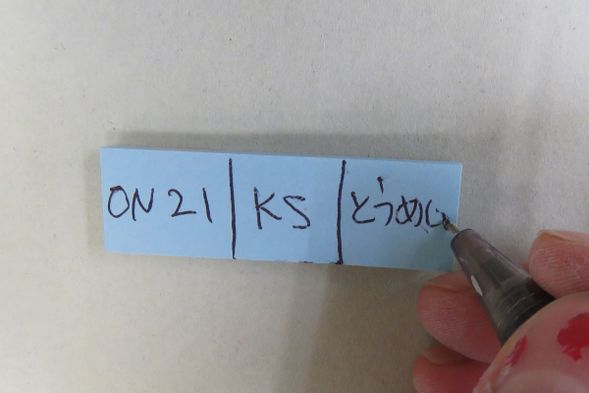 11 作品にふせんをつける:サイン/イニシャル/釉薬の色 を書いたふせんを作品につけましょう。ふせんに水をつけて作品の表側につけます。